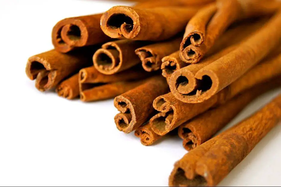 pile of cinnamon sticks over white background