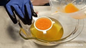 pouring orange colored lye water into oils