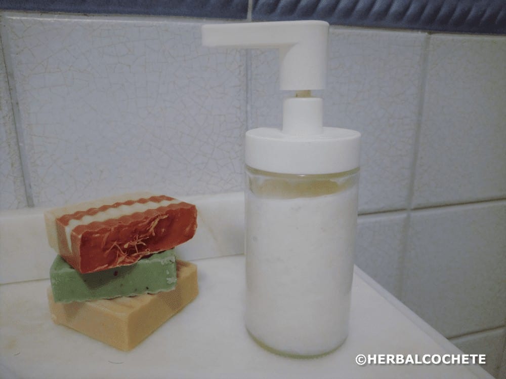 Liquid soap in dispenser and soap bars in the bathroom