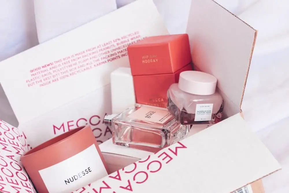 Beauty box with several salmon-coloured cosmetics displaying